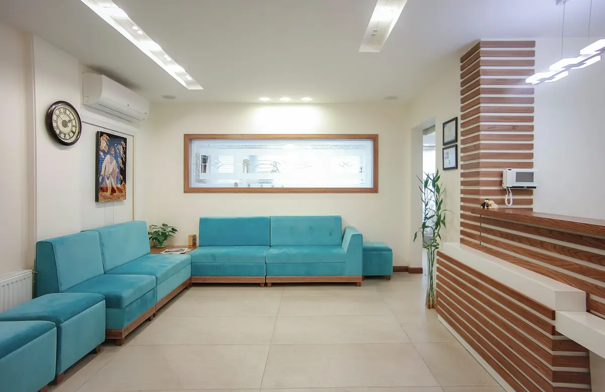 Sala de espera de una clínica dental con sillones turquesa